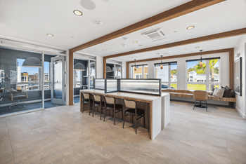 A modern kitchen with a long table and chairs.